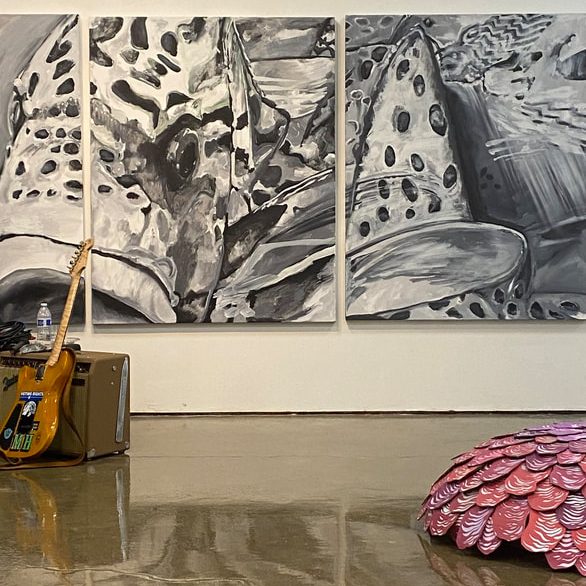 Large Black and White Fish Painting in a gallery with a guitar and pink paper shrub